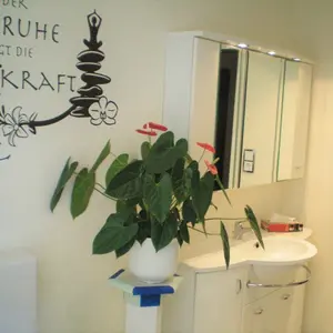 Badezimmer dekoriert mit einem Wandtattoo und Zimmerpflanze