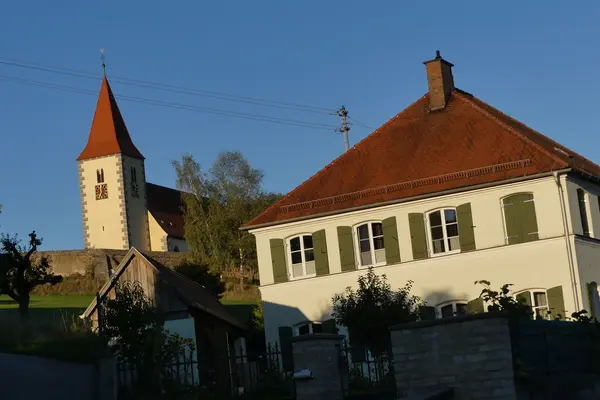 kath. Pfarrhaus Ehingen mit Kirche im Hintergrund	