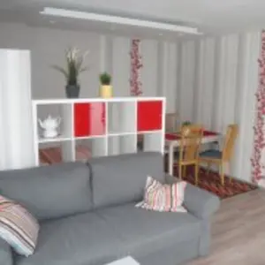 Freundliches Wohnzimmer mit Zweisitzer-Sofa