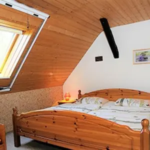 Ferienhof Kleeblatt in Westheim Schlafzimmer mit Doppelbett unter Dachschräge mit schöner Holzdecke