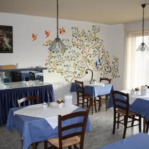 Blaues dekoriertes Esszimmer mit mehreren Einzeltischen und aufgebauten Buffet-Tischen