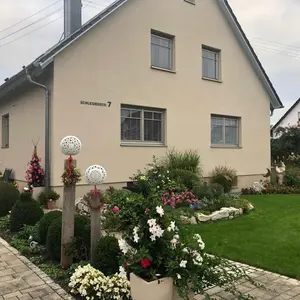 Hausansicht der Ferienwohnung Adelheid mit hübsch dekorierter Außenanlage und Rasenfläche